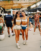 Two women posing in the same Mennillo x BeachClub outfit, smiling.