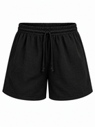 Black textured cotton drawstring shorts with an elastic waistband, shown against a plain white background.